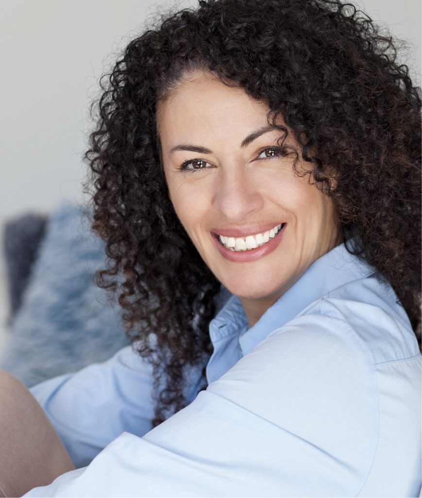 Smiling woman with dark, curly hair